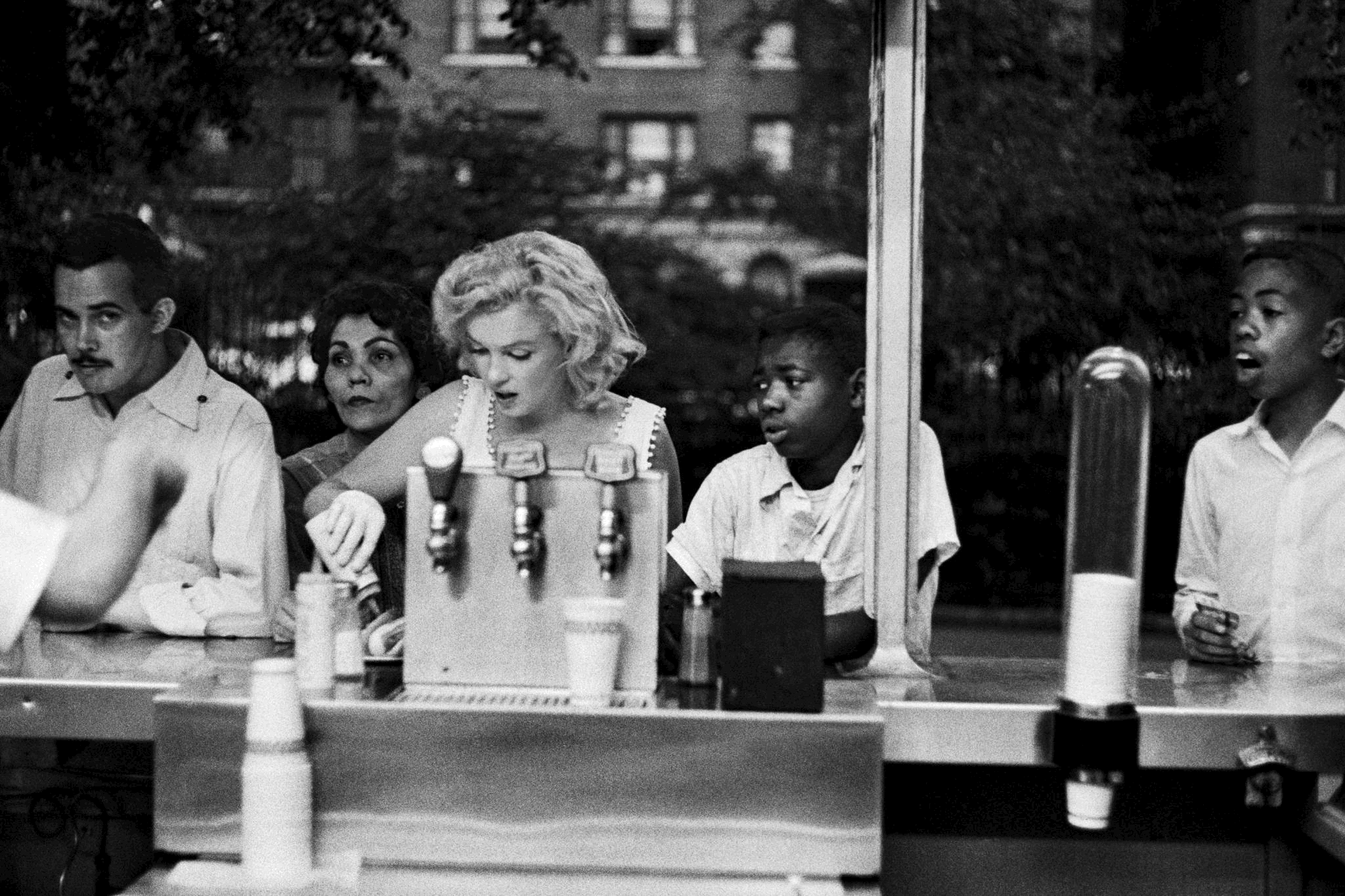 Marilyn Monroe preparing a hot dog at a counter in New York, NY (1957)