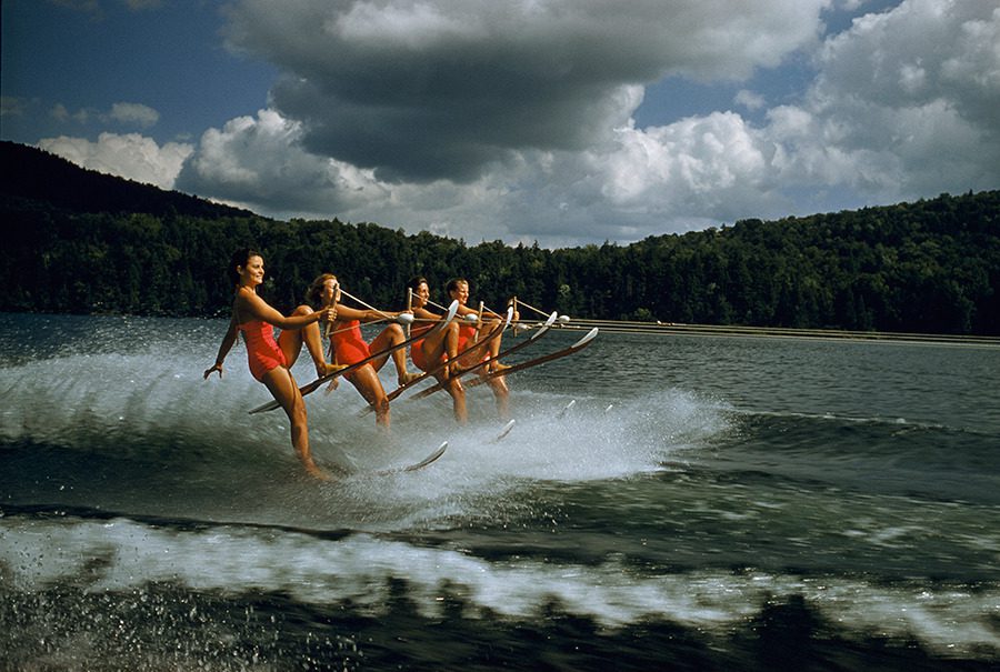 A women’s water ski team lifts skis while being towed at 23 mph on Darts Lake in New York, 1956.