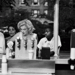 Marilyn Monroe preparing a hot dog at a counter in New York, NY (1957). Photo by Sam Shaw