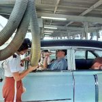 Getting cooled air piped into the car while enjoying a meal at a drive-in restaurant. Houston, Texas, 1957